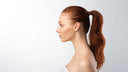 Side view portrait of teenager girl with ponytail hairstyle posing looking aside on gray studio background. Profile female headshot.